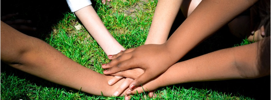 Burr Elementary students stacking their hands together on the grass